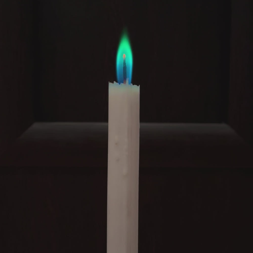 Film przedstawia biala swiece z kolorowym niebiesko-zielonym plomieniem na czarnym tle