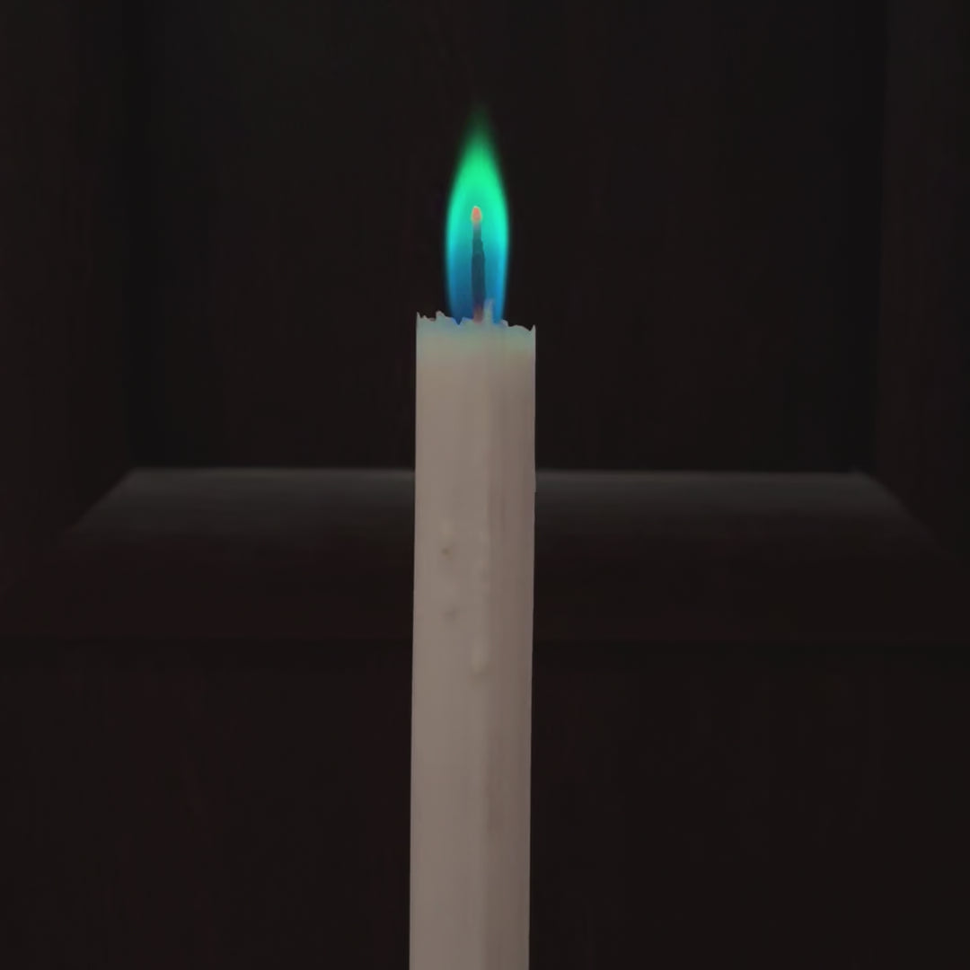 Film przedstawia biala swiece z kolorowym niebiesko-zielonym plomieniem na czarnym tle